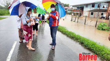 TINJAU: Jahid (kanan) ketika meninjau suasana keadaan banjir yang menjejaskan penduduk Kampung Sungai Damit.