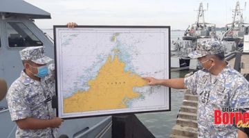 LOKASI KEJADIAN: Rusli (kanan) menunjukkan lokasi kapal kargo karam di Perairan Terumbu Segama, kira-kira 67 batu nautika dari Sandakan.