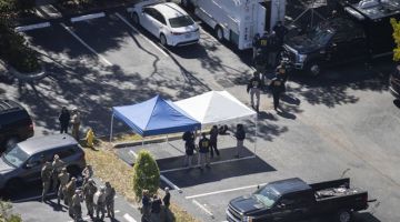 PERIKSA: Anggota penguat kuasa undang-undang memeriksa tempat di mana dua ejen FBI ditembak mati ketika menjalankan tugas di Sunrise, Florida kelmarin. — Gambar AFP
