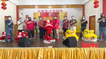 SERAH: Joachim (empat kiri) menyerahkan kostum singa kepada wakil Pertubuhan Masyarakat Tiong Hua, di Tokong Cina Ranau.