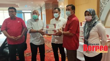 SUMBANGAN: Bung (dua kiri) menyampaikan sumbangan buah kurma kepada salah seorang ketua bahagian UMNO sempena majlis itu.