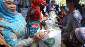 MENJELANG RAMADAN: Anak-anak yatim menerima sumbangan makanan daripada para dermawan di wilayah selatan Thailand Pattani kelmarin. — Gambar AFP