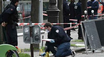 PERIKSA: Pegawai forensik memeriksa untuk petunjuk selepas seorang lelaki bersenjata                       membunuh seorang lelaki di luar hospital Henry Dunant, Paris kelmarin. — Gambar AFP