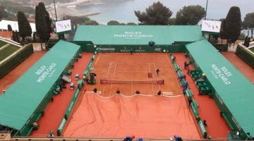 TERGENDALA: Kakitangan menutup permukaan lantai padang berikutan perlawanan yang ditunda akibat hujan pada kejohanan Monte-Carlo ATP di Monte-Carlo, Monaco, kelmarin— Gambar AFP