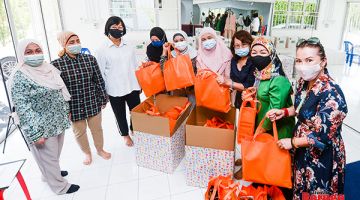 KENANGAN: Juliah bersama beberapa isteri jemaah menteri Kabinet Sabah merakamkan gambar kenangan selepas selesai membungkus kuih muih Aidilfitri