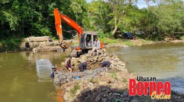 BINA EMPANGAN: Kerja membina empangan untuk pengairan sawah padi di Sungai Menanangkung Kampung Bunsit.
