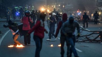 GANAS: Penunjuk perasaan bertempur dengan polis pencegah rusuhan selepas menyekat lebuh raya semasa protes antikerajaan baharu di Medellin, Colombia pada Ahad lepas. — Gambar AFP