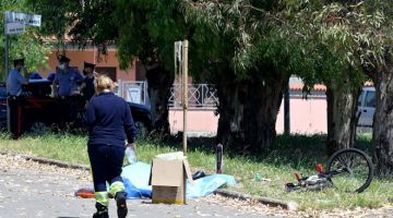 MANGSA KEADAAN: Seorang pakar forensik berjalan melintasi mayat salah seorang mangsa tembakan di  konsortium Colle Romito di Ardea, Rom, kelmarin.   — Gambar AFP