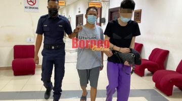 Tertuduh (tengah) dihantar ke lokap sebelum menjalani hukuman di Penjara Puncak Borneo.