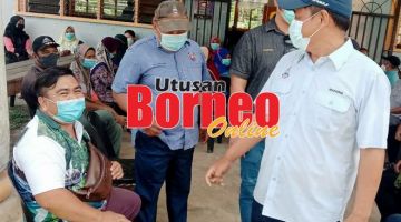 BERTANYA: Masiung (kanan) bertanyakan sesuatu kepada salah seorang penduduk di Keramuak semasa Program Outreach Vaksinasi.