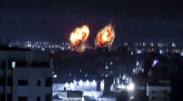 BEDILAN: Dua letupan kelihatan di atas bangunan di Semenanjung Gaza ketika tentera Israel membedil enklaf Palestin itu                pada awal pagi semalam. — Gambar AFP