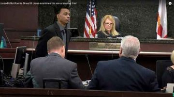 BELA DIRI: Imej dari kamera di mahkamah di Tampa, Florida pada Rabu lepas menunjukkan Oneal (berdiri) ketika sesi soal jawab dengan anak lelakinya semasa perbicaraannya atas tuduhan membunuh teman wanita dan anak perempuannya. — Gambar AFP