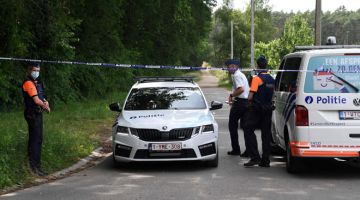 SIASAT: Anggota polis mengawal laluan masuk ke sebuah jalan desa selepas menemui mayat askar berpandangan ekstrem kanan di Dilsen-Stokkem. — Gambar AFP