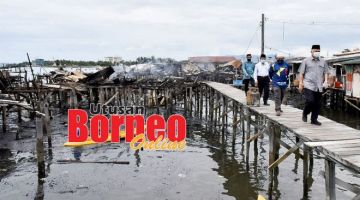 LAWAT: Arifin (kanan) melawat ke lokasi kebakaran di Kampung Tanjung Aru.