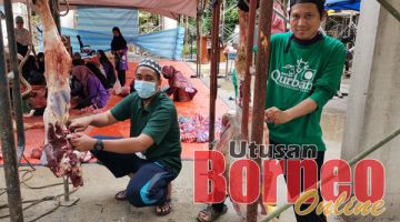 KORBAN: Rosli (kiri) turut membantu melapah daging korban untuk diagihkan kepada golongan asnaf.