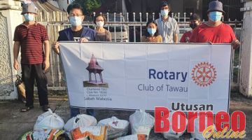 MISI BANTUAN: Ahli Kelab Rotary Tawau semasa turun padang menyampaikan bakul makanan kepada golongan memerlukan.