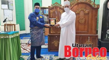 CENDERAKENANGAN: Nizam (kanan) menerima cenderakenangan MDN Sabah daripada Ismail.