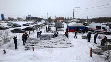 Pasukan keselamatan memindahkan khemah yang digunakan oleh pelombong Listvyazhnaya di Belovo. — Gambar AFP
