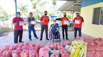 Rapelson (dua kiri) menerima bantuan bakul makanan daripada CIMB Alumni untuk diagihkan kepada ahli-ahli PERAIS dan OKU memerlukan di sekitar Kuching dan Samarahan.