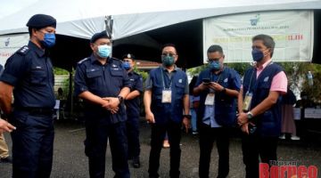 Aidi (dua kiri) bersama Ketua Polis Daerah Kuching ACP Ahsmon Bajah berjumpa dengan petugas Suruhanjaya Pilihan Raya (SPR) di pusat mengundi.