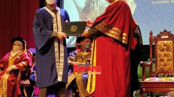 TAHNIAH: Mornie (kanan) menyampaikan skrol diploma kepada graduan.