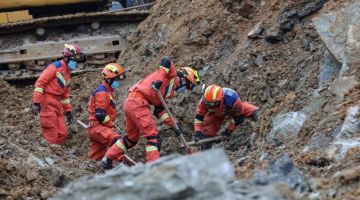 TANAH RUNTUH: Anggota penyelamat menggali tanah runtuh yang mengorbankan 14 orang di barat daya wilayah Guizhou, China kelmarin. — Gambar AFP