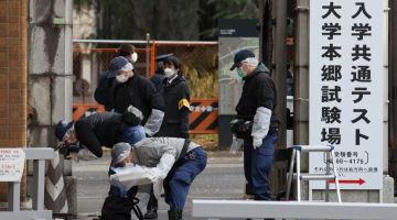 SIASATAN: Pegawai polis melakukan siasatan di hapadan pintu masuk Universiti Tokyo selepas dua orang pelajar dan warga emas maut ditikam, di Tokyo, kelmarin. — Gambar AFP