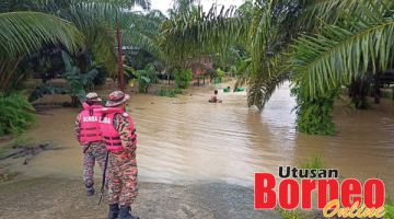 PANTAU: Pasukan bomba memantau kawasan yang dinaiki banjir kilat.