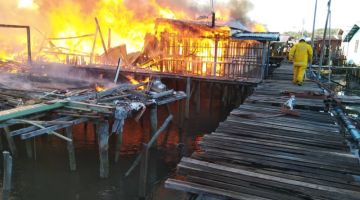 TERBAKAR: Api marak memusnahkan 176 rumah setinggan atas air di Kampung Landung Ayang Laut di sini.