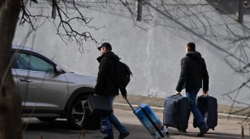 Kakitangan dilihat meninggalkan Kedutaan Rusia di Kyiv bersama dengan bagasi mereka kelmarin. — Gambar AFP 