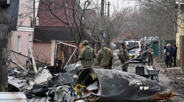 Anggota tentera Ukraine memeriksa serpihan pesawat udara yang tidak dikenal pasti yang terhempas di kawasan kediaman di Kyiv kelmarin. — Gambar AFP