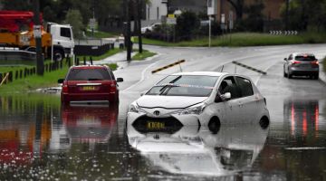 DINAIKI AIR: Kenderaan terkandas di dalam banjir ekoran hujan lebat melanda Sydney, semalam. — Gambar AFP