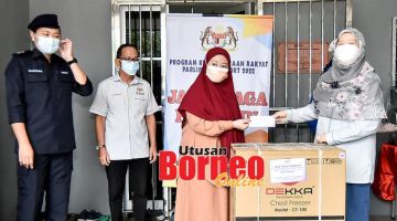 TERIMA: Salah seorang belia (dua kanan) menerima barang berniaga dan dana yang disampaikan oleh Azizah (kanan) di perkarangan pejabat PKRP Beaufort bagi kawasan DUN Klias.