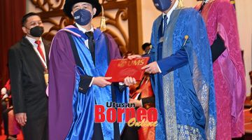 TAHNIAH: Hajiji (kanan) menyempurnakan penganugerahan Ijazah Doktor Falsafah kepada Teoh Jia Long (graduan cacat penglihatan) pada Majlis Konvokesyen UMS Ke-22.