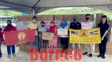 SAMPAIKAN: Siti Aminah (empat kiri) menyampaikan sumbangan kepada salah seorang penduduk sambil disaksikan oleh Iskandar (tiga kanan) dan Darren (dua kanan).