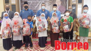 SUMBANGAN: Nizam (tengah), Samin (dua kanan) bersama sebahagian murid sekolah yang menerima bantuan tersebut.