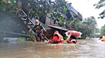 Anggota keselamatan memindahkan penduduk dari rumah mereka yang dinaiki air di bandar Panitan, wilayah Capiz akibat hujan lebat yang dibawa oleh Ribut Tropika Megi.-- AFP