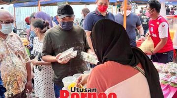 MEMBELI: Bung ketika membeli juadah berbuka di salah sebuah gerai bazar ramadhan di Asia City Kota Kinabalu semasa tinjauan tersebut.