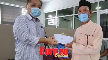 SERAHKAN: Robert (kiri) menyerahkan sumbangan kepada Pengerusi Masjid Ukhuwah Apin- Apin, Mokshin Salleh.