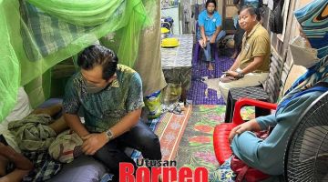 ZIARAH: Jamawi bersama isteri menziarahi salah seorang penduduk yang uzur semasa program itu.