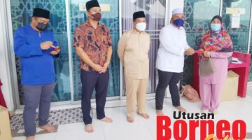 SUMBANGAN: Ghazali (dua kanan) dan Hamild (tengah) semasa menyampaikan sumbangan kepada golongan asnaf dalam majlis tersebut.