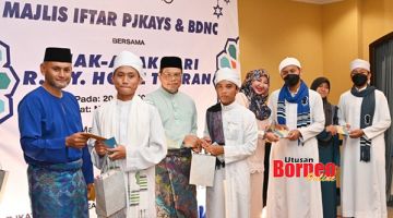 SERAH: Eddie (dua kiri), Feroz (kiri) bersama Timbalan Presiden PJKAYS, Rozalind Joanes (tiga kiri) dan Junaidah (empat kiri) menyerahkan duit raya dan beg-beg hadiah kepada anak-anak Home Tuaran.