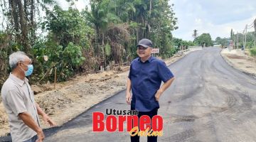 TINJAU: Robert (kanan) berkesempatan berbual dengan salah seorang penduduk yang tinggal berhampiran jambatan baharu itu semasa melakukan tinjauan ke lokasi pembinaan jambatan berkenaan.