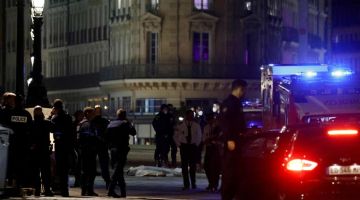 Polis melakukan siasatan di lokasi kejadian tembakan di mana dua orang (tengah) ditembak mati pihak polis di Paris, semalam. — Gambar AFP