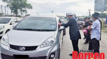 BUBUR LAMBUK: Nizam berkesempatan mengagihkan bubur lambuk kepada pengguna jalan raya.