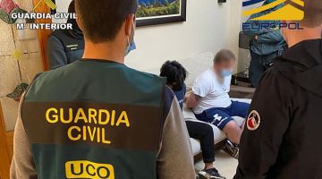 Gambar serahan Spanish Guardia Civil kelmarin menunjukkan anggota Spanish Guardia Civil berdiri di sebelah suspek yang digari semasa operasi untuk menumpaskan sindiket penggubahan wang. — Gambar AFP