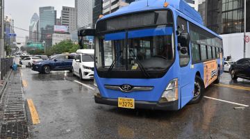Sebuah bas dan beberapa kereta yang terkandas akibat banjir kilat bergelimpangan di jalan raya selepas hujan lebat melanda daerah Gangnam di Seoul, semalam. - Gambar AFP