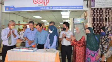 Dr Rundi  (tiga kiri) memotong kek sebagai simbolik perasmian Agromart Koperasi Petani Bintulu Sarawak Berhad sambil disaksikan Liew (dua kiri), pegawai-pegawai SKM dan tetamu lainnya di Bintulu, hari ini.