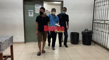 Tertuduh Mukhsin (tengah) diiring polis keluar dari bilik tahanan mahkamah Kuching hari ini.