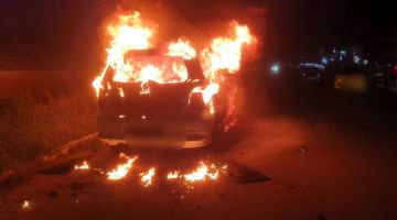TERBAKAR: Keadaan kenderaan MPV yang terbakar di Jalan Bundusan di sini.